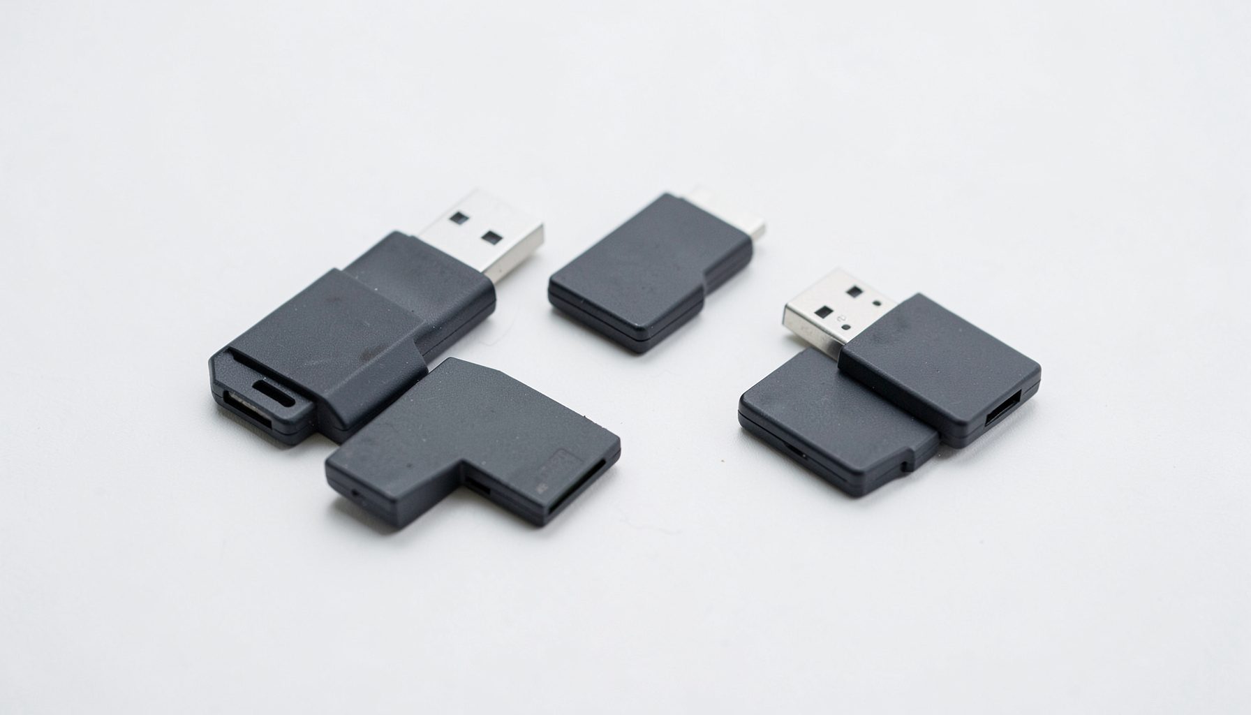 Несколько флеш-карт и USB-накопителей, разложенных на светлой поверхности, минималистичная композиция
